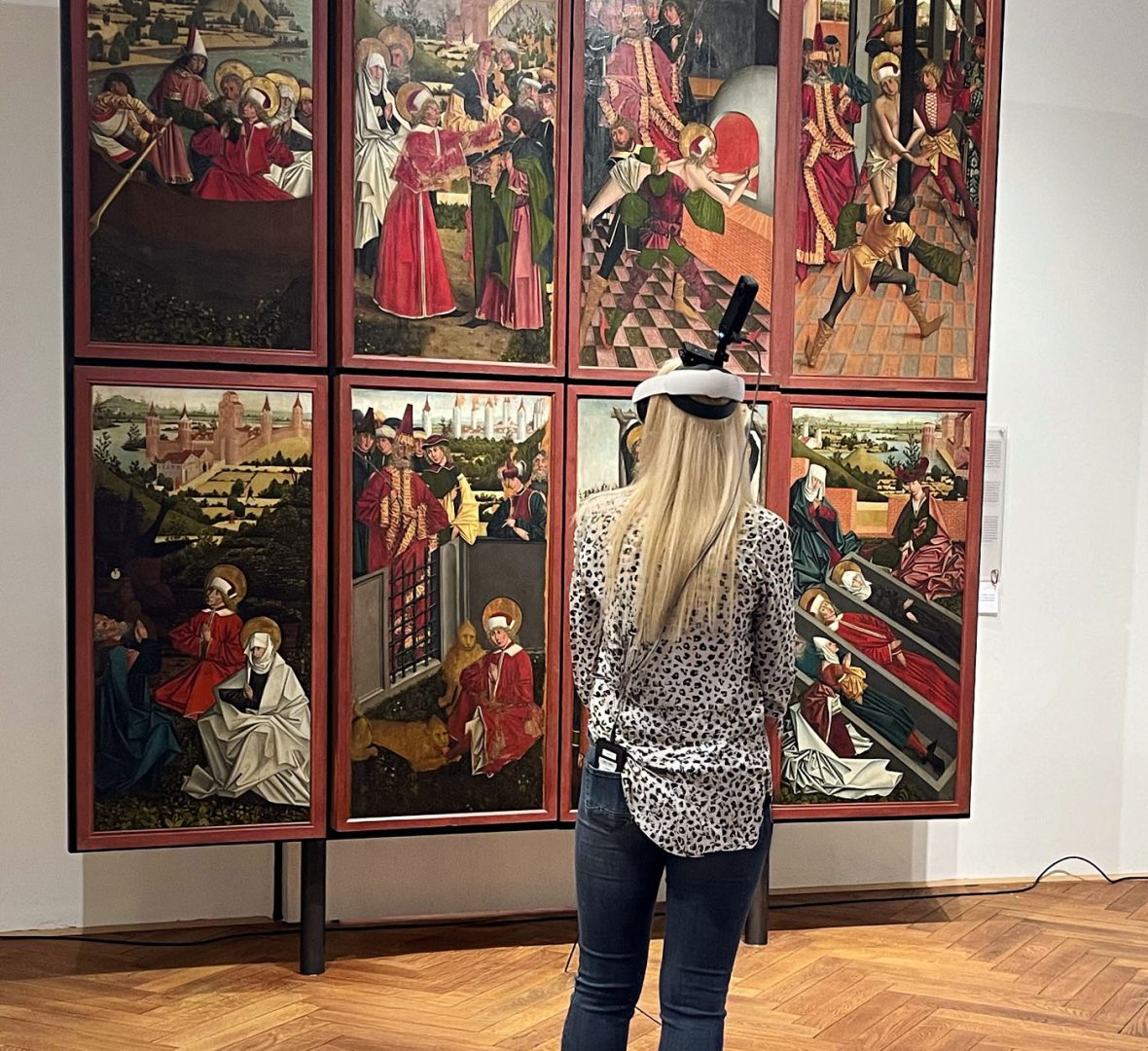 Guide mit VR-Headset und 360°-Kamera vor einem Gemälde im kärnten.museum